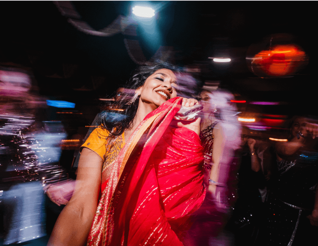 A woman wearing a sari dances on the dancefloor